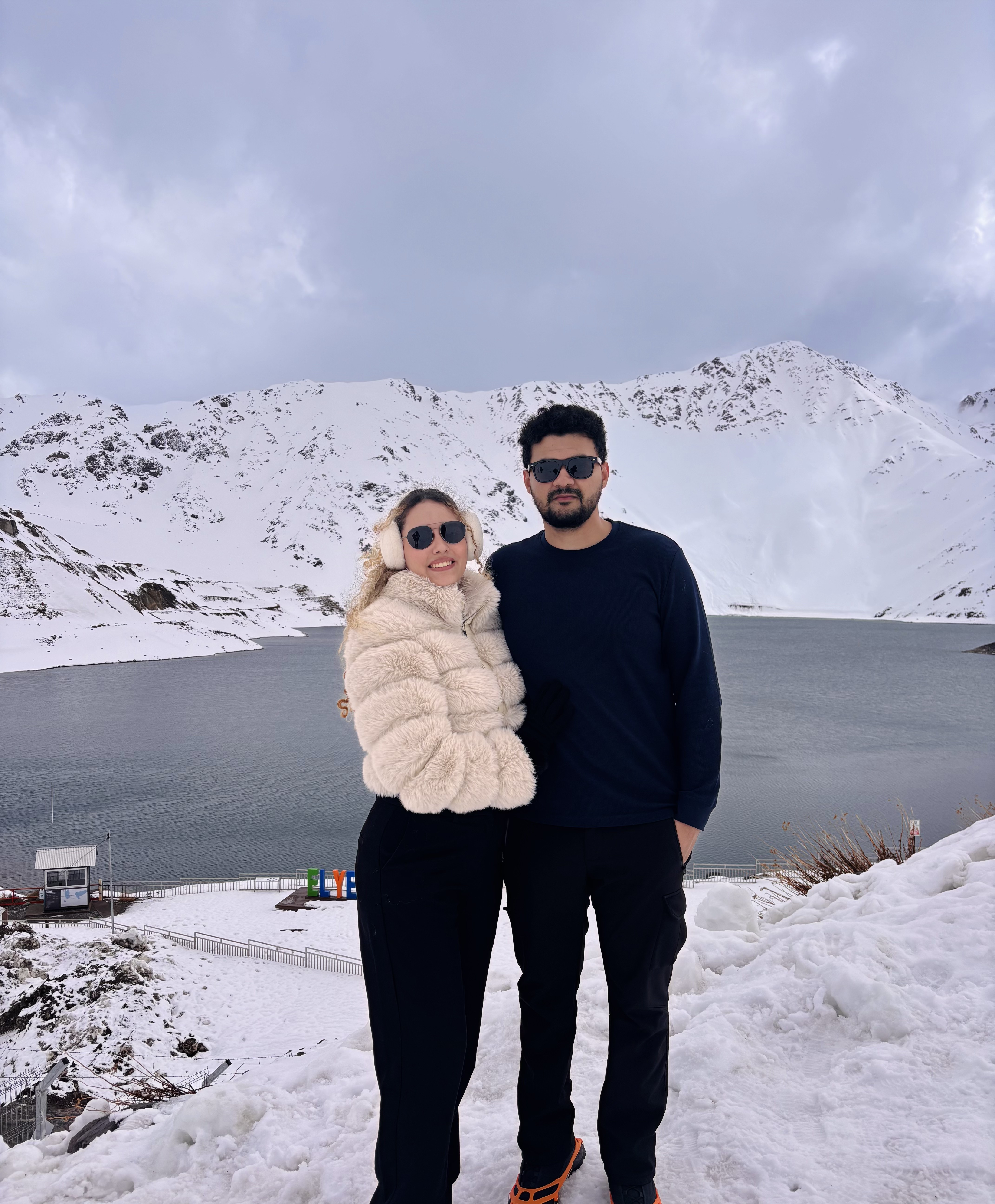 Casal em uma viagem entre montanhas nevadas